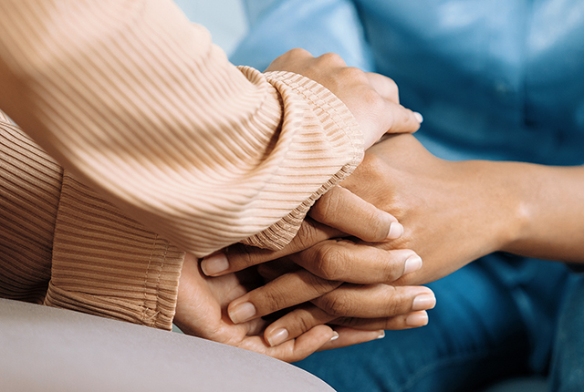 two people holding hands in comfort